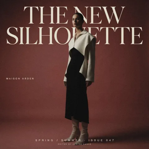 A high-fashion editorial poster for “THE NEW SILHOUETTE”. Large, perfectly legible typography, elegant oversized serif headline, a model wearing sculptural avant-garde clothing in a minimalist studio, dramatic side lighting, black, ivory, and muted red color palette, refined magazine cover composition, luxury fashion campaign.